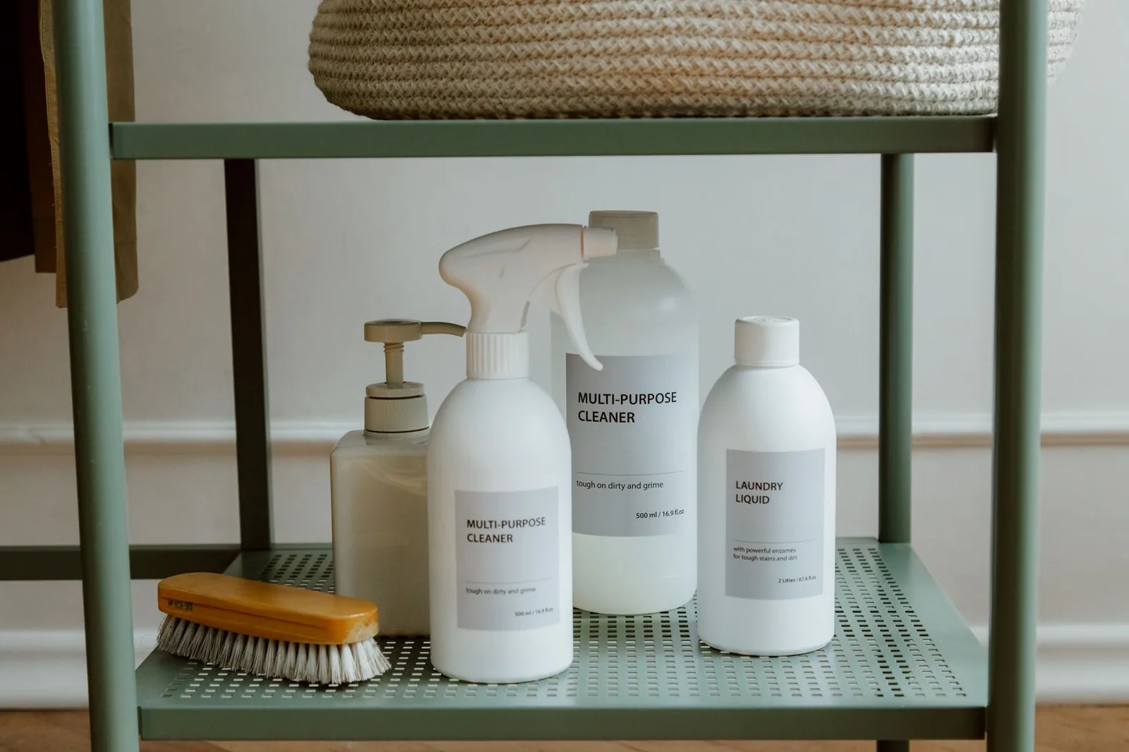 Bottles of cleaning products lined up on a metal shelf