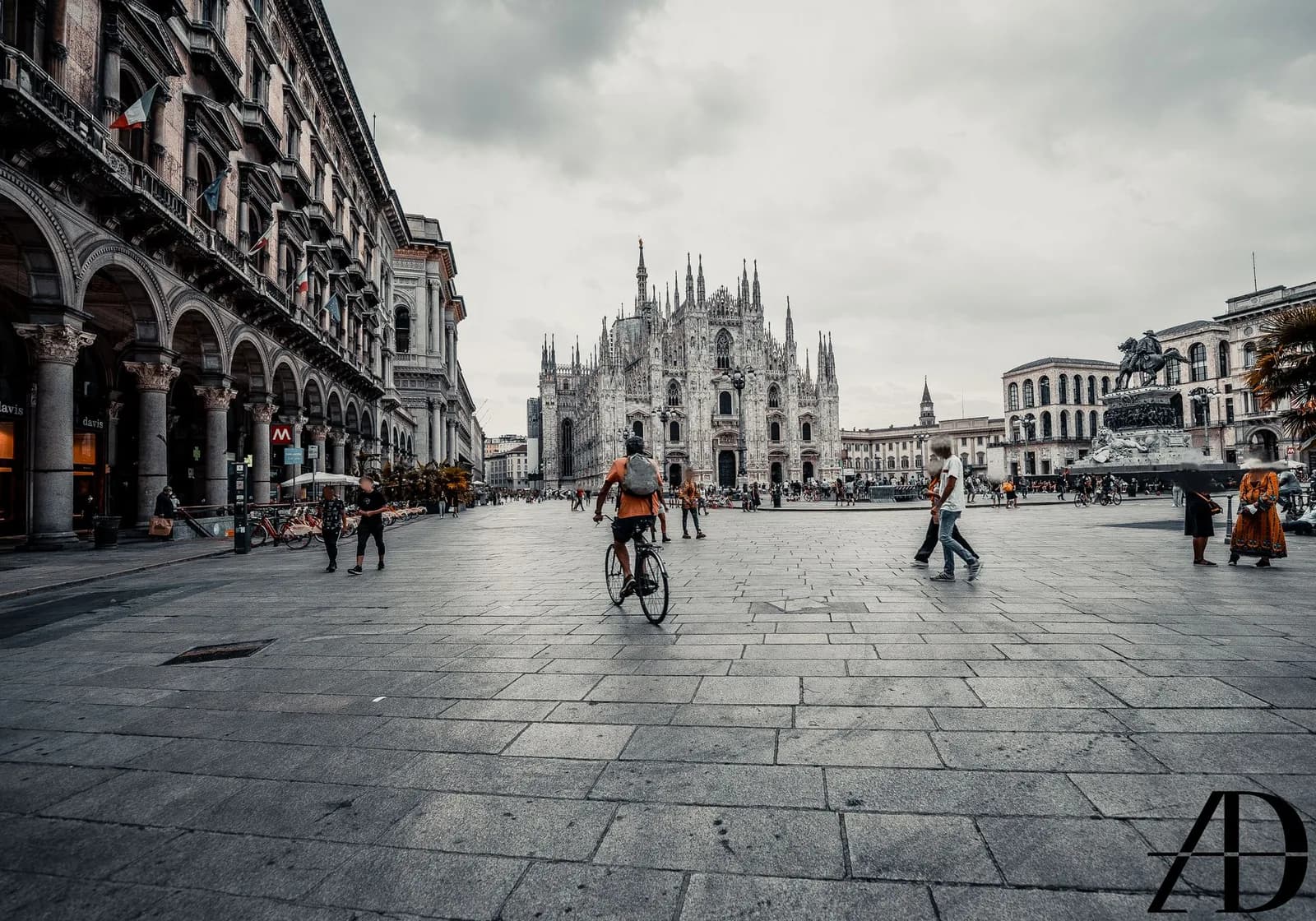 Piazza del Duomo a Milano con ciclisti e passanti davanti alla cattedrale