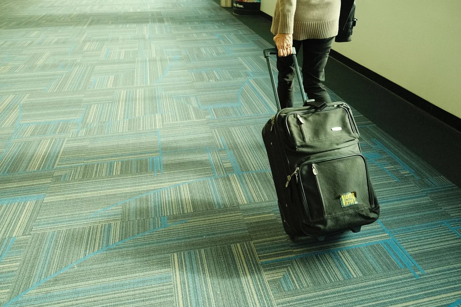 Una persona cammina con il trolley lungo il corridoio di un aeroporto