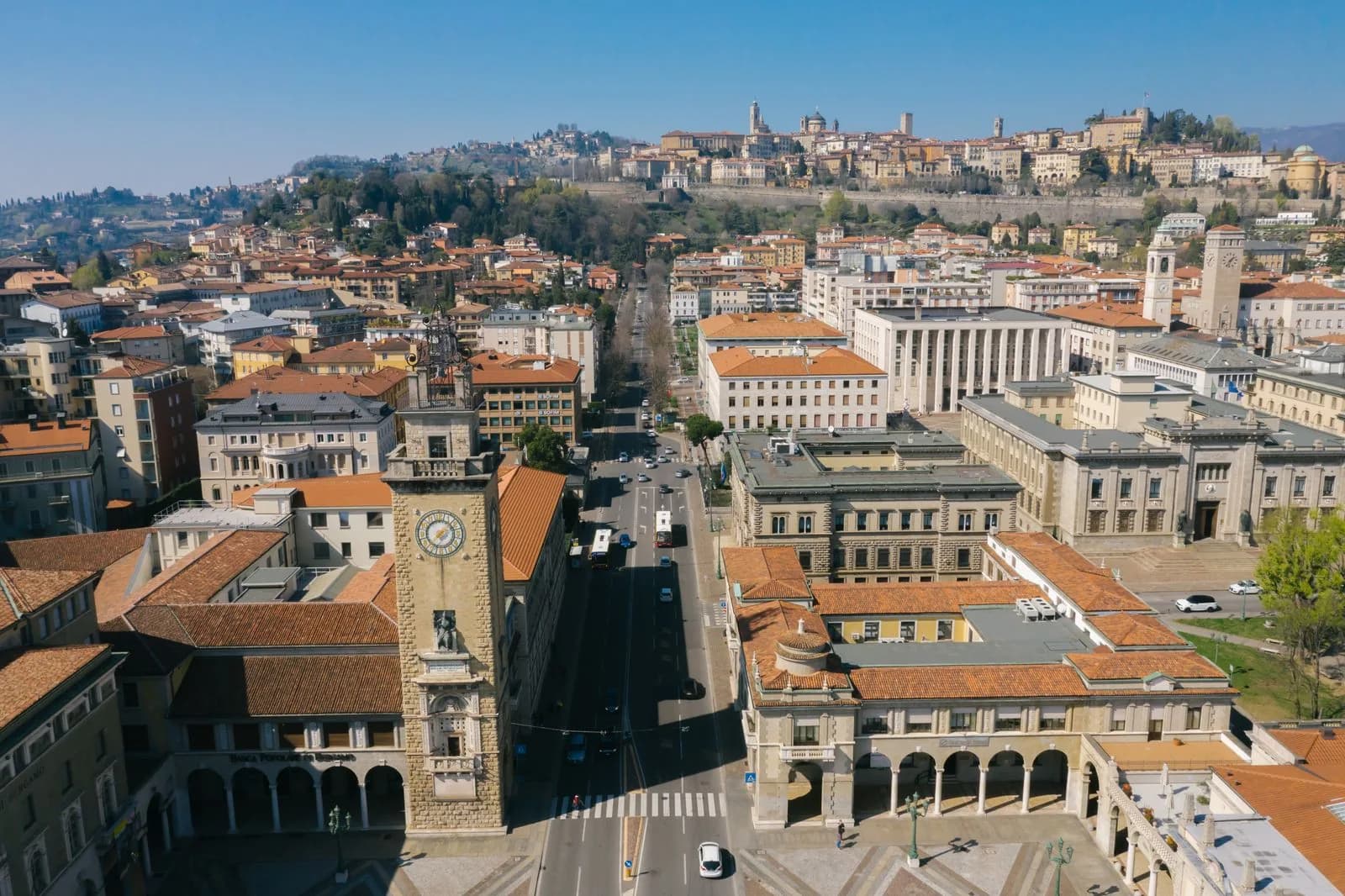 Veduta aerea di Bergamo: la Città Bassa in primo piano e la Città Alta sulla collina.