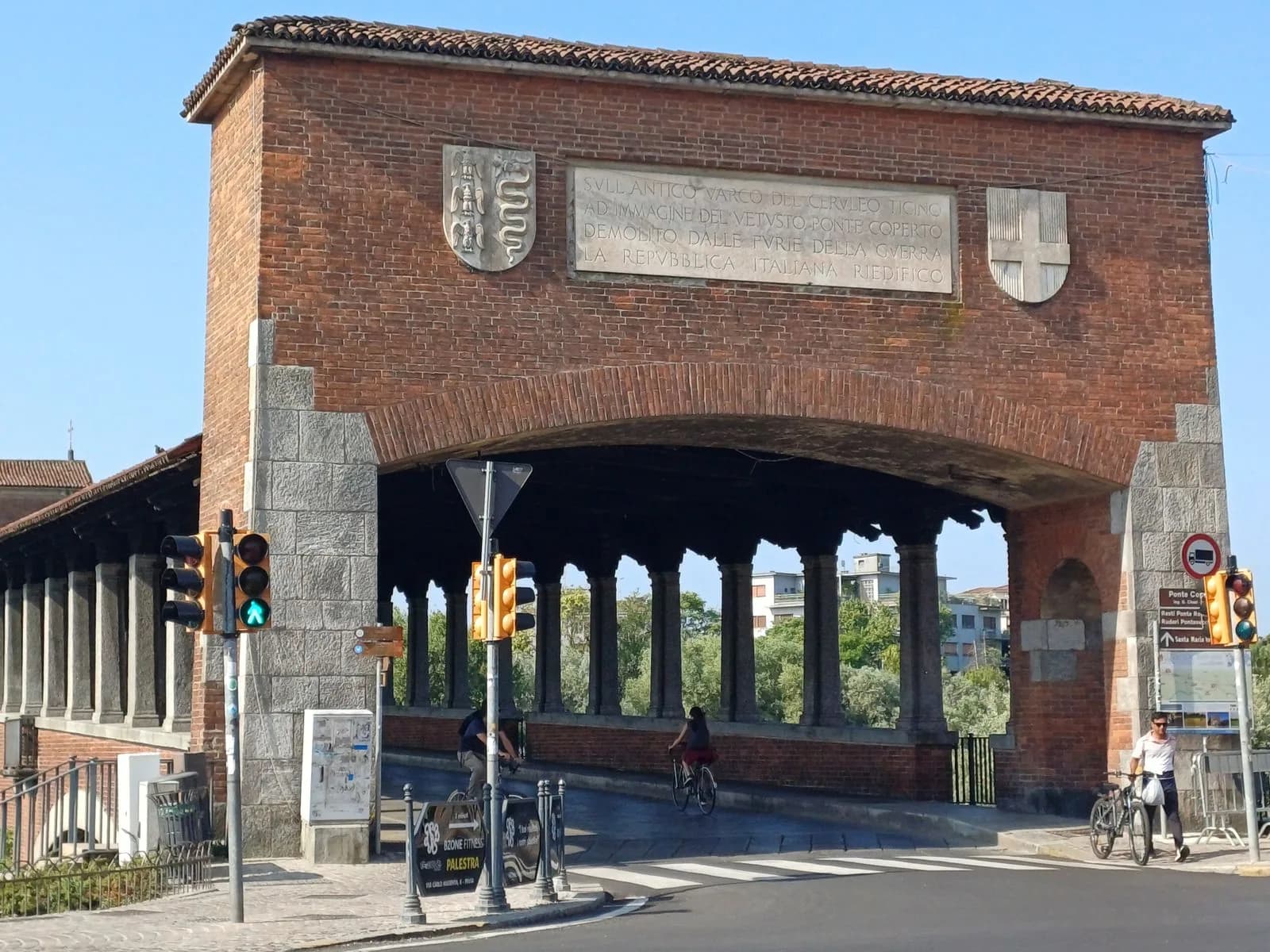 L'ingresso del Ponte Coperto di Pavia, con una persona che passa in bicicletta.