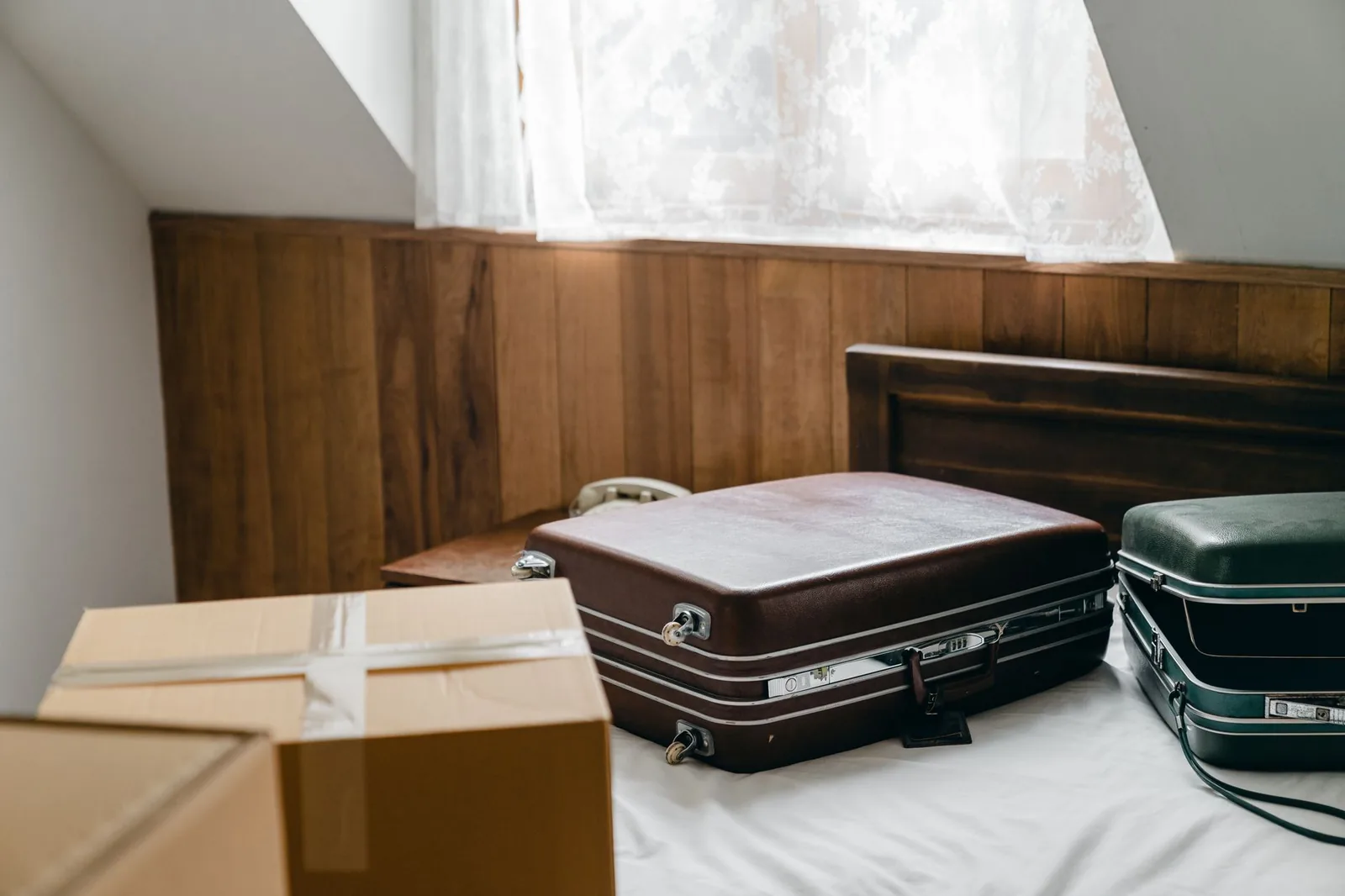Valigie sul letto e scatoloni chiusi in una stanza da liberare fra un ospite e l'altro.