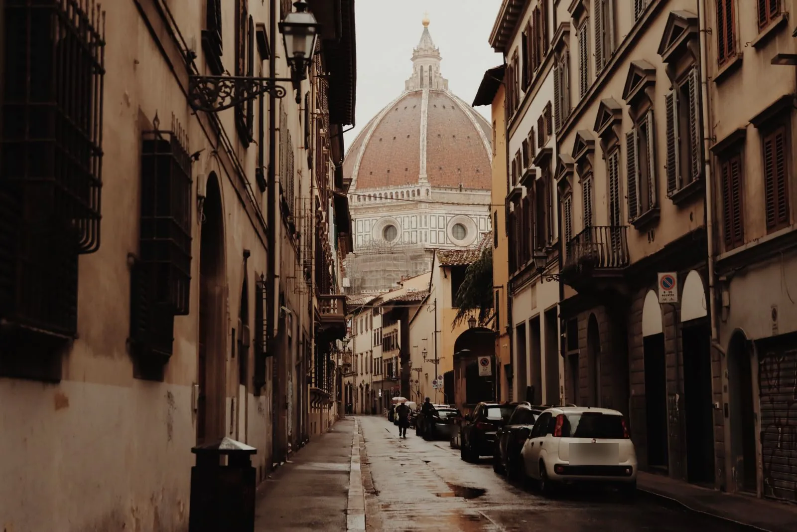 Una via del centro storico di Firenze con la cupola del Duomo in fondo