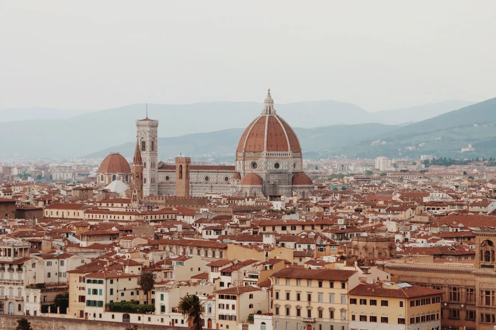 Tetti rossi del centro storico, il campanile di Giotto e le colline dietro la città.